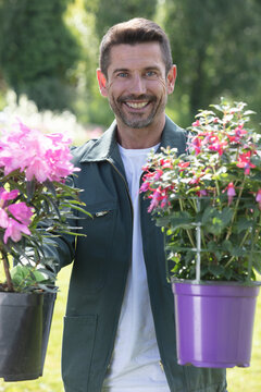 happy gardener holding pots of flowers