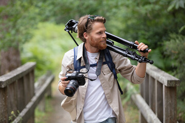 photographer carrying camera with tripod