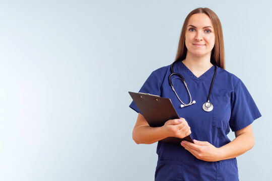 Female nurse or doctor with clipboard against a blue background