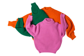 Three knitted sweaters of different colors lie one on top of the other in a chaotic arrangement,...