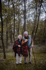 Fototapeta premium Senior couple walking together in autumn forest.
