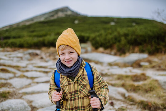 Portrait of little boy hiking in mountains.