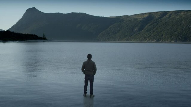Unrecognizable Man Looking Out over Lake, Rear View, Gentle Pan.