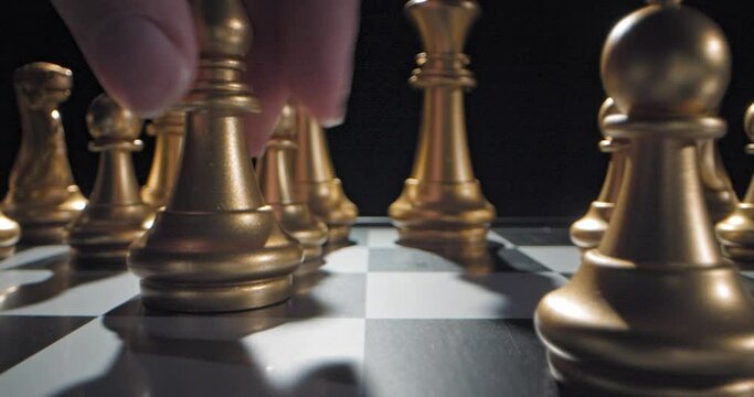 Gold bishop moved forward during chess game, low angle dolly in