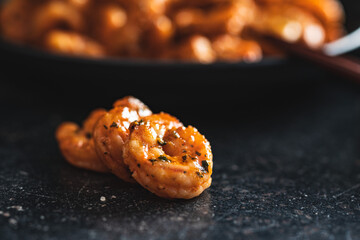Grilled tiger shrimps on black table.