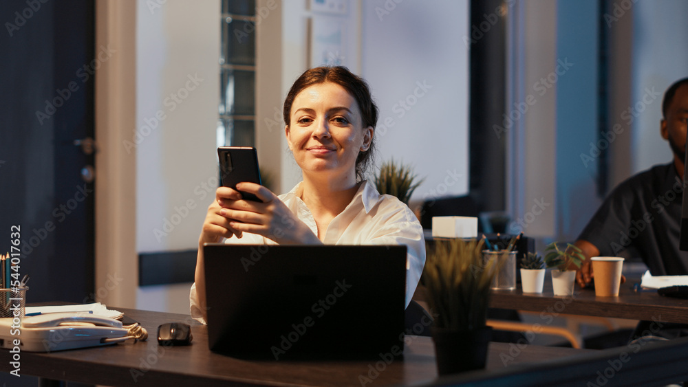 Poster portrait of happy office worker texting messages on smartphone, using investment app to work with fi