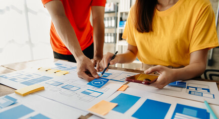  UX developer and ui designer brainstorming about mobile app interface wireframe design with...