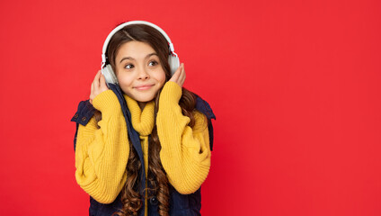 child smile in hat listening music in headphones, copy space, technology
