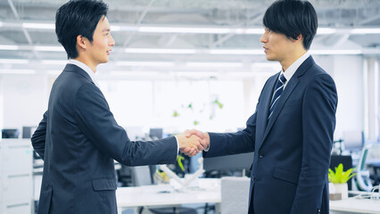 オフィスで握手するビジネスマン