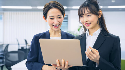 ノートパソコンを見る二人の女性会社員