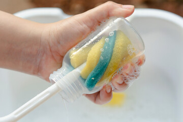 Washing baby bottle. Mother's hand washing the baby bottle..