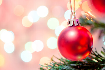 Christmas decoration. Red balls hanging on pine branches Christmas tree garland and ornaments over abstract bokeh background with copy space