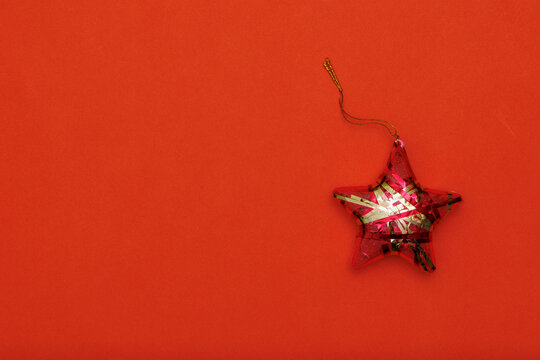 Christmas toy in the shape of a star on a red background. Christmas background.