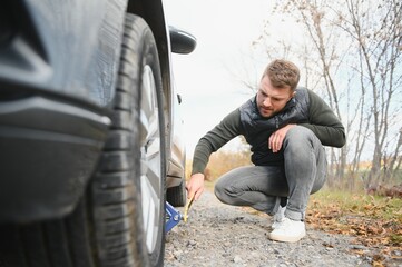 A young man with a black car that broke down on the road,copy space.