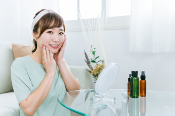 化粧品・コスメで保湿する日本人女性（カメラ目線）
