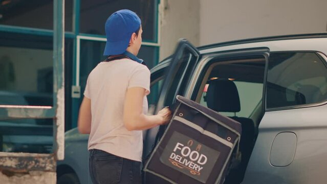Woman delivery service worker leaving car to deliver food package at front door, giving meal order to client. Taking fastfood takeaway backpack from vehicle, working as restaurant carrier.