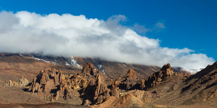 Spain, Canary Islands, Rock formations inEl Teide National Park withMount Teide shrouded in clouds in background