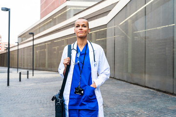 Thoughtful female doctor with shoulder bag walking on footpath