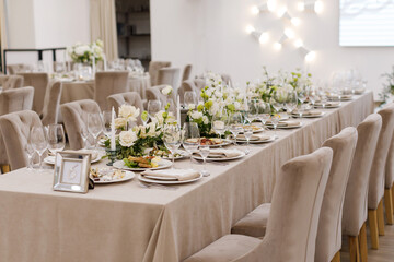 Tables setting at a luxury wedding. Table for guests. Dishes and drinks. Wedding table preparation.