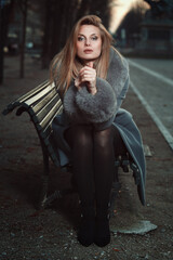 Fototapeta na wymiar Beautiful woman portrait on a park bench