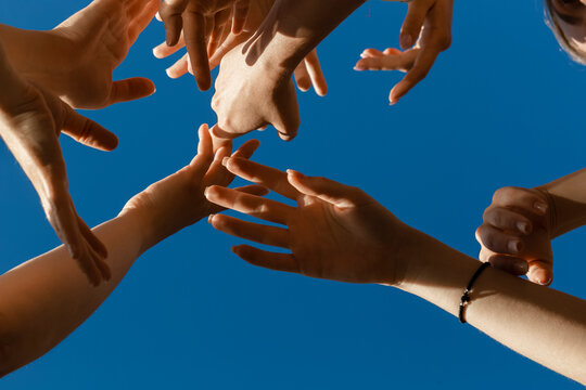 Hands of young women under blue sky
