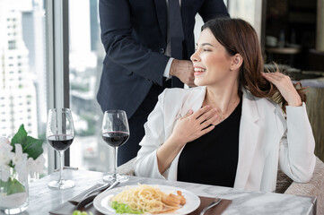 Happy Asia woman getting pearl necklace gift from husband at restaurant hotel with city out of window background