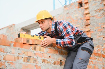 Construction worker man in work clothes and a construction helmet. Portrait of positive male...