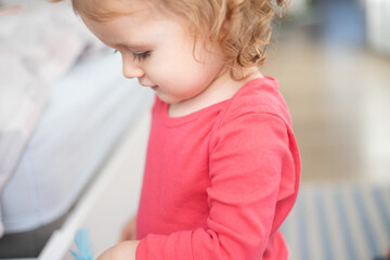 toddler girl looks down  - obrazy, fototapety, plakaty
