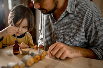 Father and son making wooden toys at home