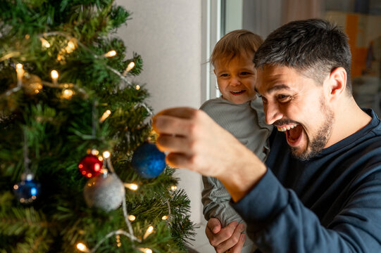 Happy Father With Son Looking At Christmas Decoration