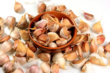 Lots of organically grown garlic cloves on a white background