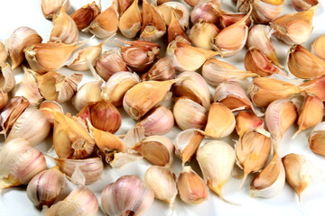 Lots of organically grown garlic cloves on a white background