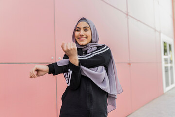 Happy arab muslim woman exercising. Islamic fitness female training outdoors