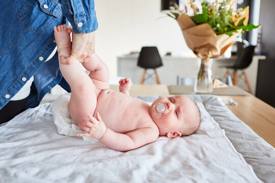 Mutter wechselt die Windeln von Baby mit Schnuller