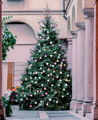 Christmas tree with colorful ornaments in front of buildings in the city.Milan, Italy