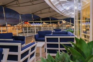 Champagne sparkling wine and cocktail longdrink on outdoor patio terrace deck of luxury cruiseship cruise ship liner yacht in port pre dinner drinks bar service