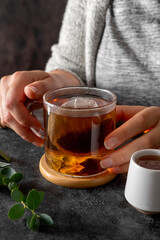 Black tea in glass cup, morning hot drink. Tea bag. Lifestyle, moody photo