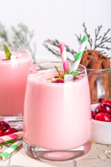 Healthy winter Christmas drink, cranberry oatmeal smoothie of yogurt, with fresh cranberries on beige tiled table, copy space
