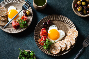 Breakfast on Valentine's Day - fried eggs in the shape of a heart and olives. Healthy breakfast. Rice cakes with eggs and hamon. Romantic breakfast. Top view.