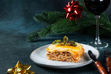 Piece of tasty hot lasagna on dark background. Traditional italian lasagna. Italian food. Close up...
