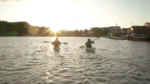 Couple padeling kayac in the sunset
