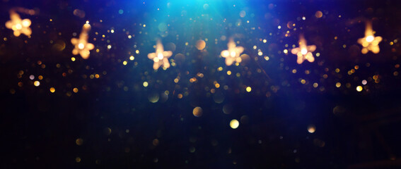 Christmas warm gold garland lights over dark background with glitter overlay - obrazy, fototapety, plakaty