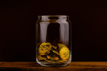 gold coin in glass bottle on black scene, money and gold saving concept