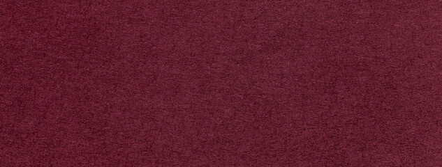 Texture of old dark red color paper background, macro. Structure of a vintage craft wine cardboard.