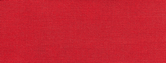 Texture of bright red color background from textile material with wicker pattern. Vintage ruby...