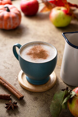 Coffee with milk or latte with cinnamon in blue ceramic cup. Autumn comfort drink.