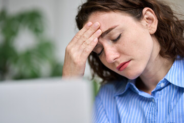 Tired depressed dizzy young professional business woman employee office worker touching head...