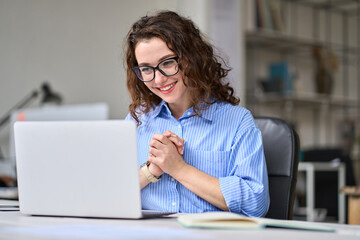 Young happy business woman professional employee feeling excited looking at laptop reading good news online email getting salary growth opportunity, satisfied with good result success at work desk. - obrazy, fototapety, plakaty