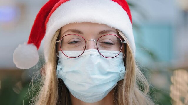 Close up female portrait Caucasian woman lady girl nurse doctor wearing red Santa Christmas hat cap and eyeglass and protective medical face mask New Year xmas pandemic coronavirus covid ill sick
