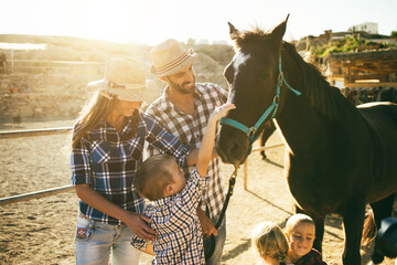 Happy family with horse having fun at farm ranch - Focus on animal eye - obrazy, fototapety, plakaty